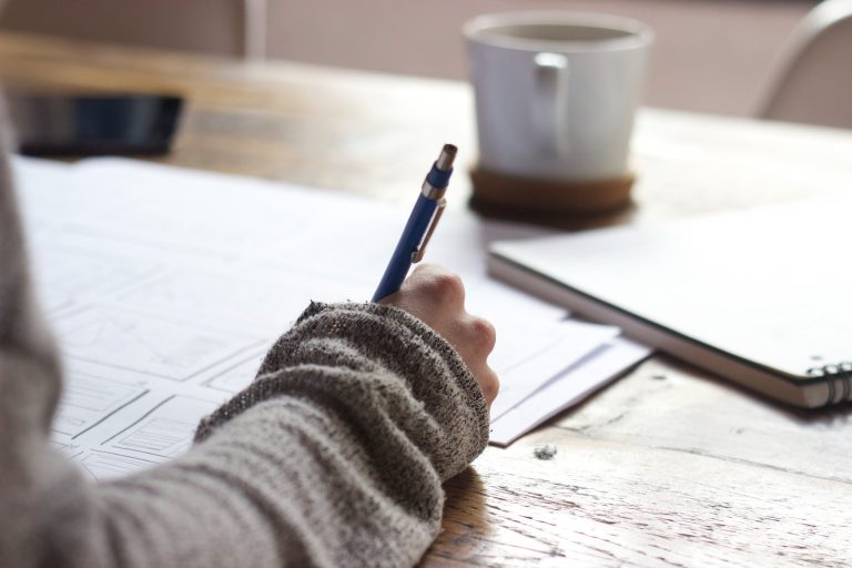 Working from home at desk with cup of coffee and papers 